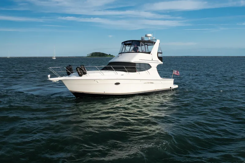 Slide: The Image of 2005 Silverton 34 Convertible yacht cruising on open water under a clear blue sky. - 7