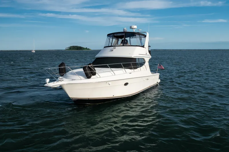 Slide: The Image of 2005 Silverton 34 Convertible yacht cruising on open water under clear skies. - 8