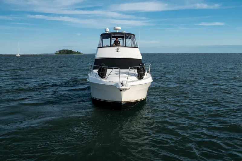 Slide: The Image of 2005 Silverton 34 Convertible yacht cruising on open water under a clear blue sky. - 9