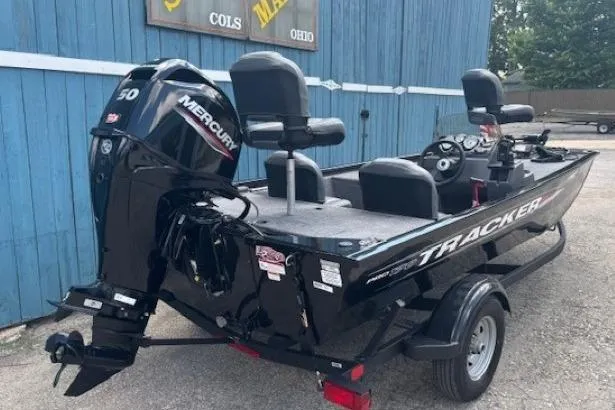 Slide: The Image of 2025 Tracker Pro 170 boat with Mercury engine, parked near a blue building. - 3