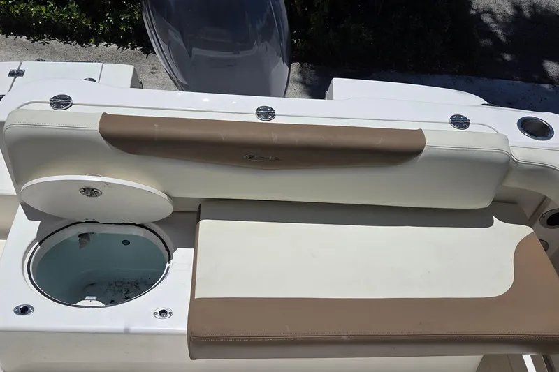 Slide: The Image of 2017 Robalo R222 Center Console boat with open storage compartment and cushioned seating. - 11