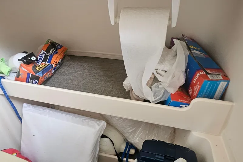 Slide: The Image of Storage compartment in a 2017 Grady-White Fisherman 257 boat with supplies and paper towels. - 20