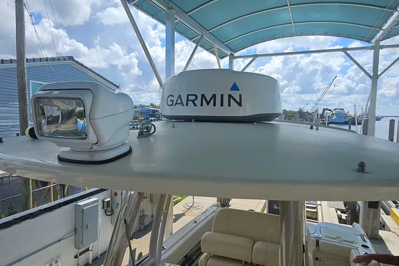 Slide: The Image of 2017 Grady-White Fisherman 257 boat with Garmin radar and spotlight under a blue canopy. - 25