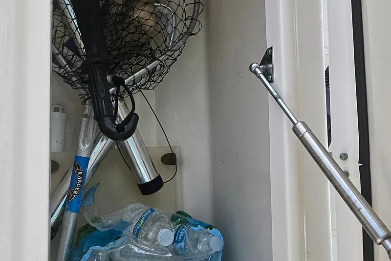 Slide: The Image of Storage compartment on a 2017 Grady-White Fisherman 257 with fishing gear and water bottles. - 32