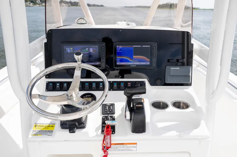 Slide: The Image of 2016 Sea Hunt Ultra 225 boat dashboard with steering wheel and navigation screens. - 17