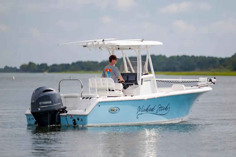 Slide: The Image of 2016 Sea Hunt Ultra 225 boat on water, featuring Yamaha engine, clear sky background. - 4