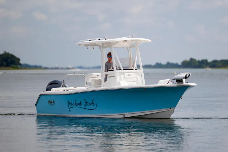 Slide: The Image of 2016 Sea Hunt Ultra 225 boat on calm water, featuring a sleek blue design. - 6
