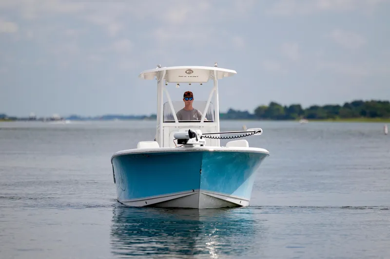 Slide: The Image of 2016 Sea Hunt Ultra 225 boat on calm water, front view with clear sky background. - 7