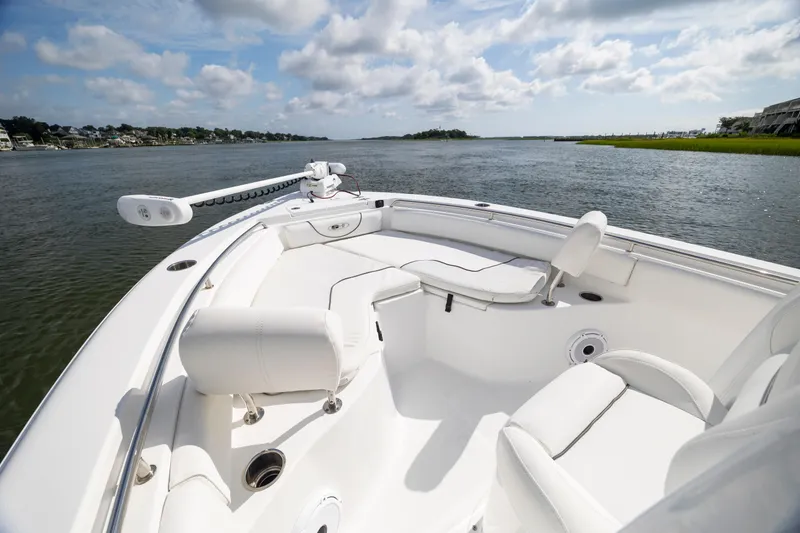 Slide: The Image of 2016 Sea Hunt Ultra 225 boat on calm water under a partly cloudy sky. - 8