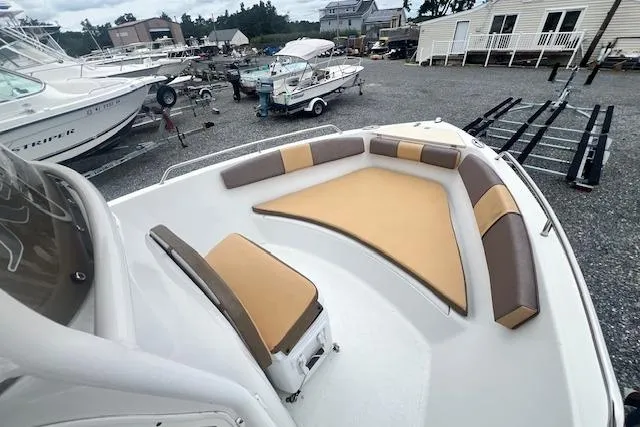 Slide: The Image of 2019 Key Largo 2100 WI boat with tan and brown seating, docked in a marina. - 10
