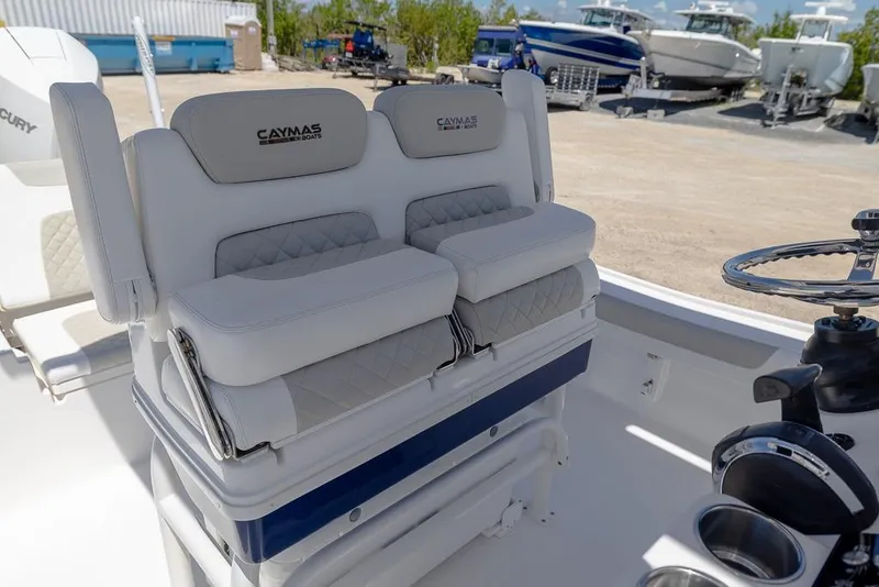 Slide: The Image of 2022 Caymas 26 HB boat interior with cushioned seating and steering wheel. - 13