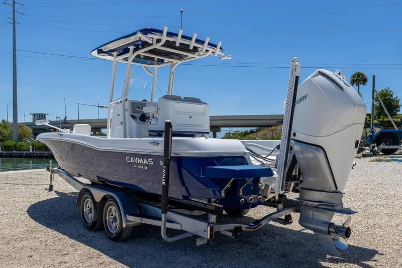 Slide: The Image of 2022 Caymas 26 HB boat on trailer with Mercury outboard engine, parked near water. - 5