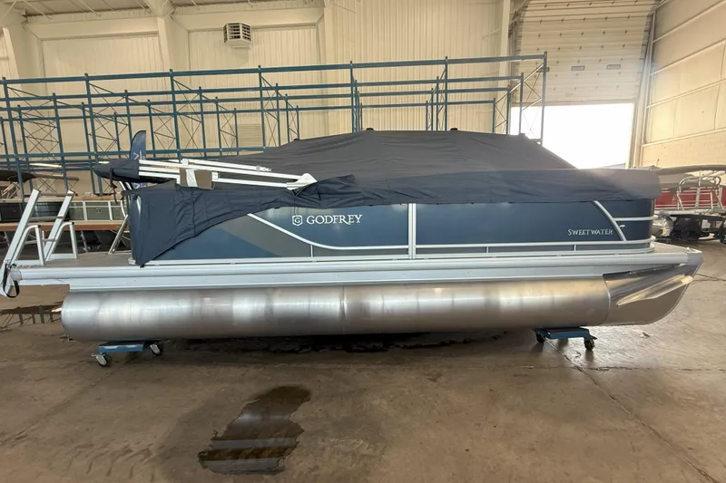 Slide: The Image of 2026 Godfrey Sweetwater 2086 C pontoon boat covered in a warehouse setting. - 2