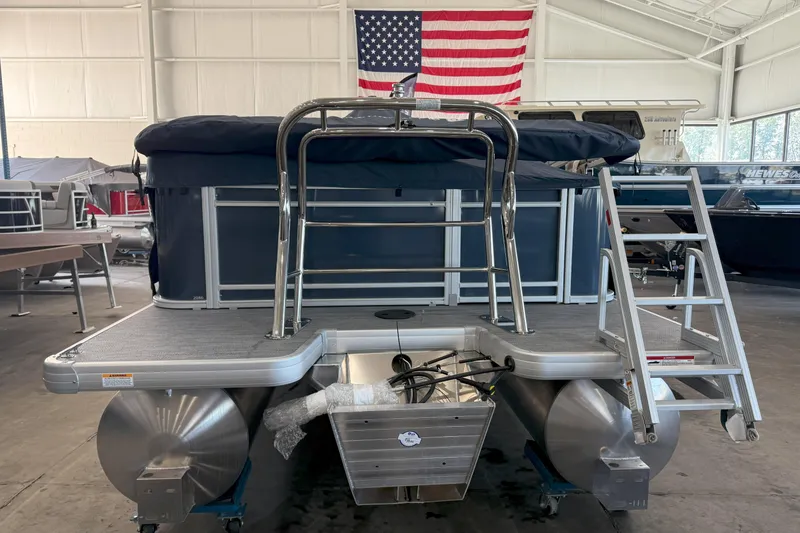 Slide: The Image of 2026 Godfrey Sweetwater 2086 C pontoon boat in showroom with American flag backdrop. - 3