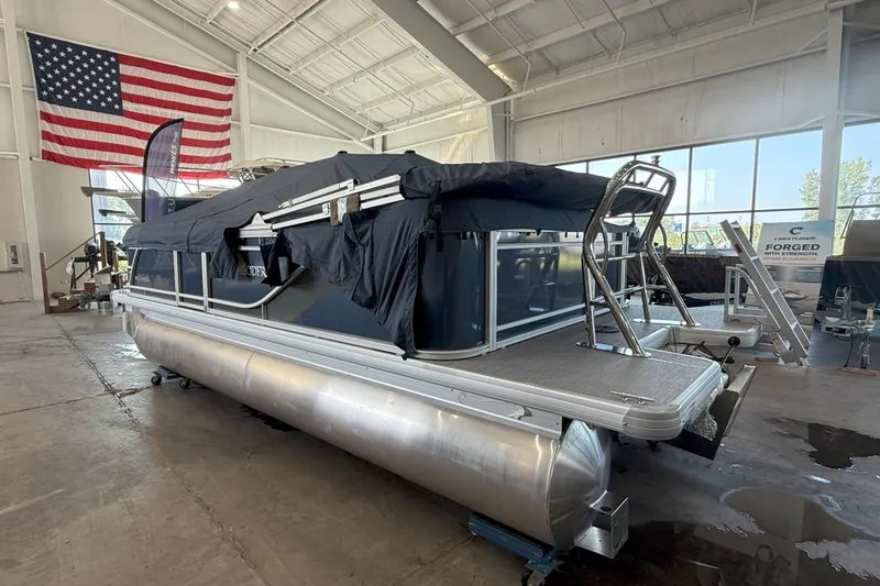Slide: The Image of 2026 Godfrey Sweetwater 2086 C pontoon boat in showroom with American flag backdrop. - 5
