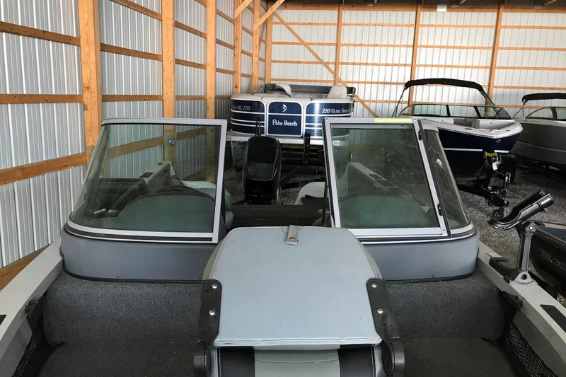 Slide: The Image of 2009 Triton DV 17 Liberty boat stored in a metal shed with other boats. - 11
