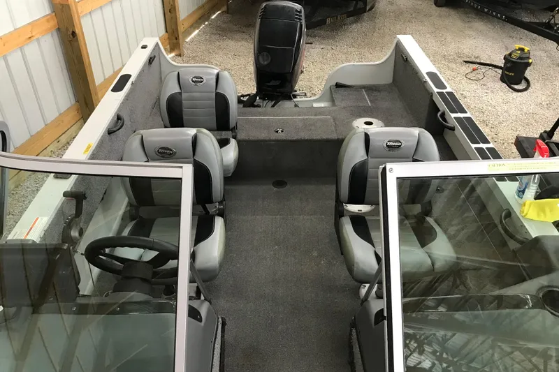 Slide: The Image of 2009 Triton DV 17 Liberty boat interior with seating and steering wheel in a garage. - 17