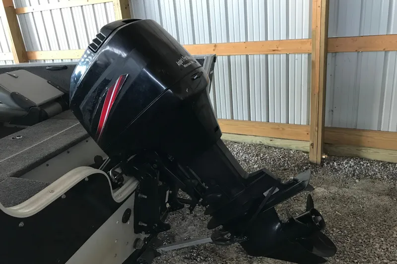 Slide: The Image of 2009 Triton DV 17 Liberty boat with outboard motor in a storage shed. - 4