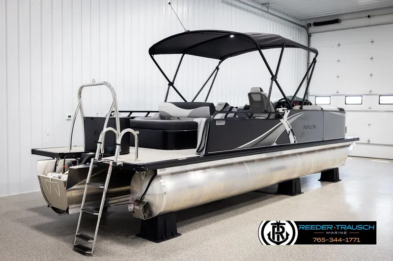Slide: The Image of 2026 Avalon LSZ VRB pontoon boat in showroom with canopy and ladder. - 6