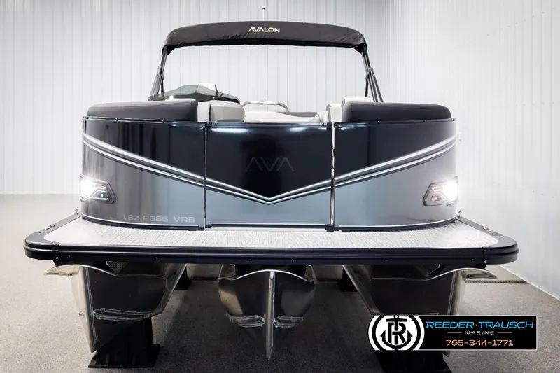 Slide: The Image of 2026 Avalon LSZ VRB pontoon boat in showroom, rear view with sleek design and lighting. - 8