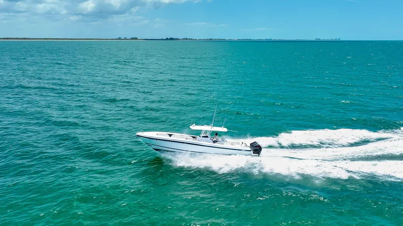 Slide: The Image of 2018 Intrepid 375 Open boat cruising on turquoise ocean waters under a partly cloudy sky. - 12