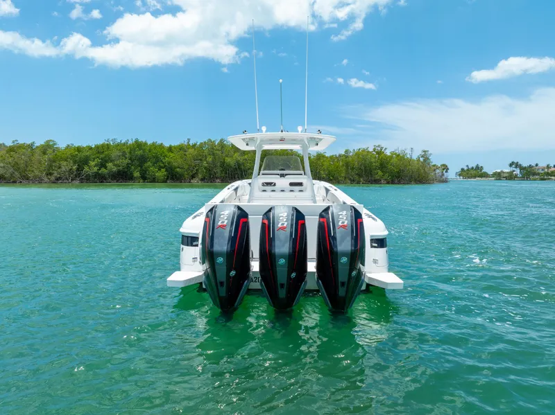 Slide: The Image of 2018 Intrepid 375 Open boat with triple engines on turquoise water, clear sky background. - 16