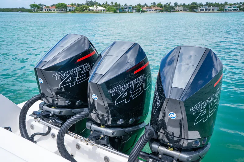 Slide: The Image of Triple Mercury Racing 450R engines on a 2018 Intrepid 375 Open boat, docked by a scenic waterfront. - 18