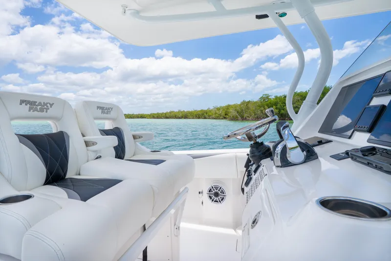 Slide: The Image of 2018 Intrepid 375 Open boat interior with plush seating and modern controls on a sunny day. - 2