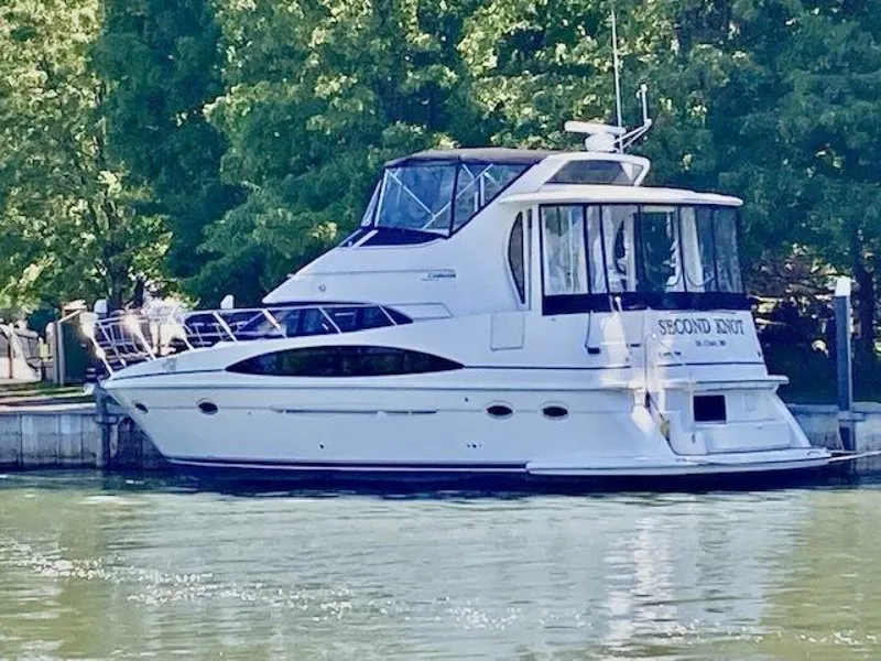 The Image of 2003 Carver 396 Aft Cabin MY yacht docked by lush greenery. - 1