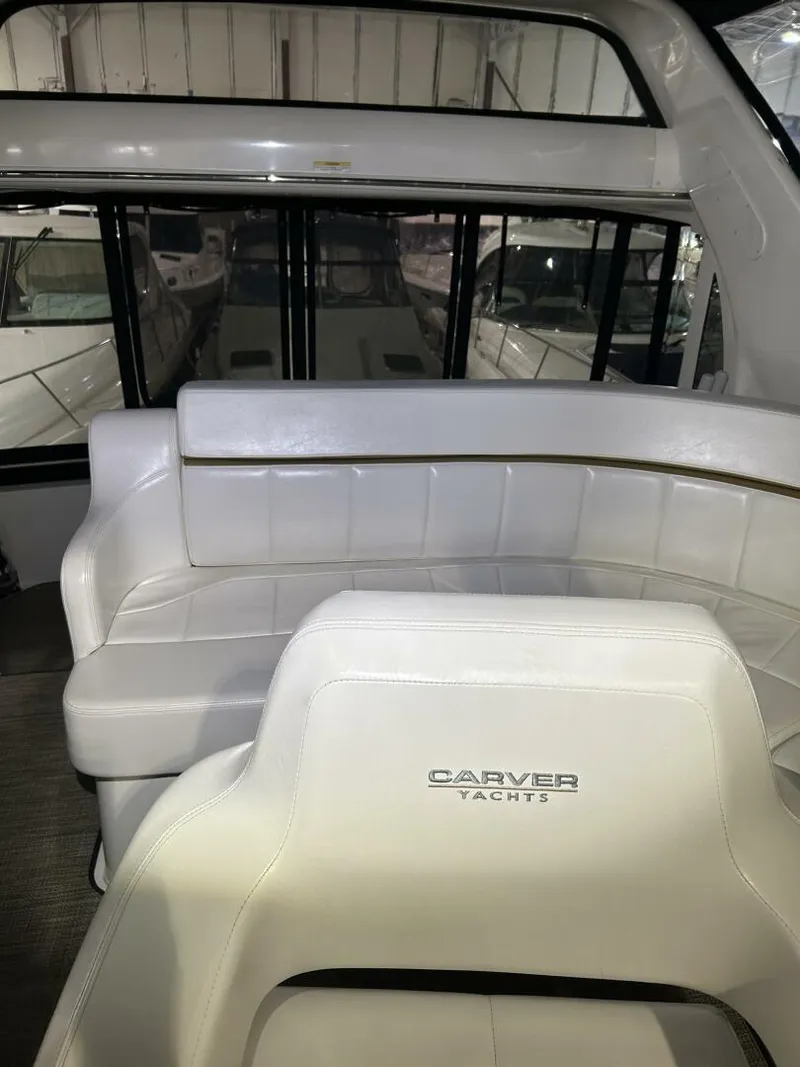 Slide: The Image of 2003 Carver 396 Aft Cabin MY interior with white seating in a yacht showroom. - 30