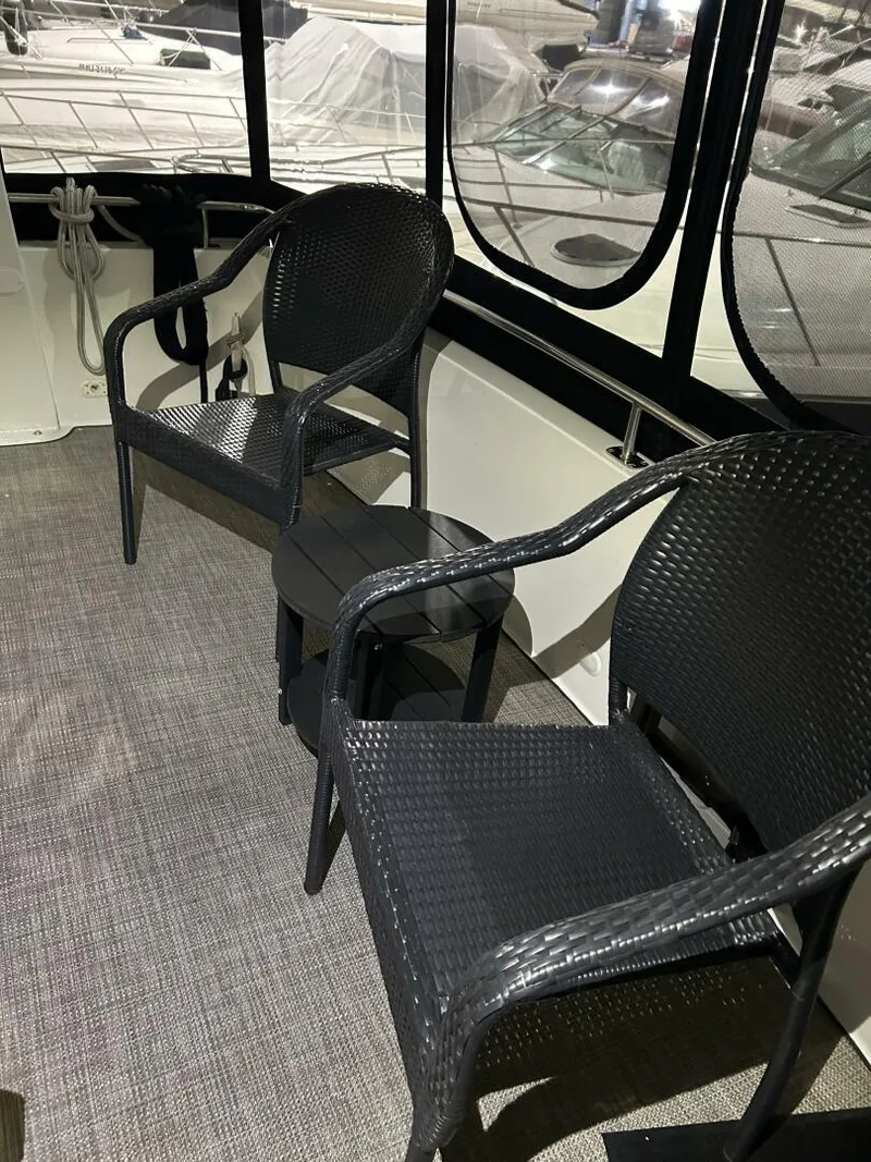 Slide: The Image of 2003 Carver 396 Aft Cabin MY interior with black wicker chairs and carpeted floor. - 39