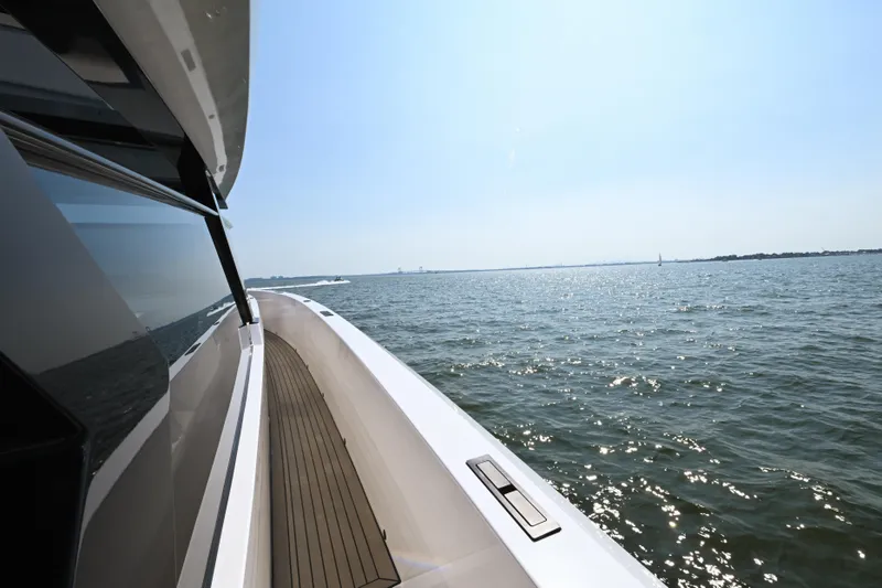 Slide: The Image of 2022 Vanquish VQ58 yacht cruising on open water under clear blue sky. - 11