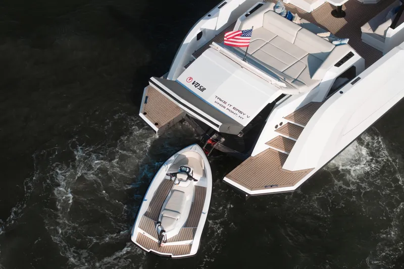Slide: The Image of Aerial view of 2022 Vanquish VQ58 yacht with tender boat, American flag displayed. - 28