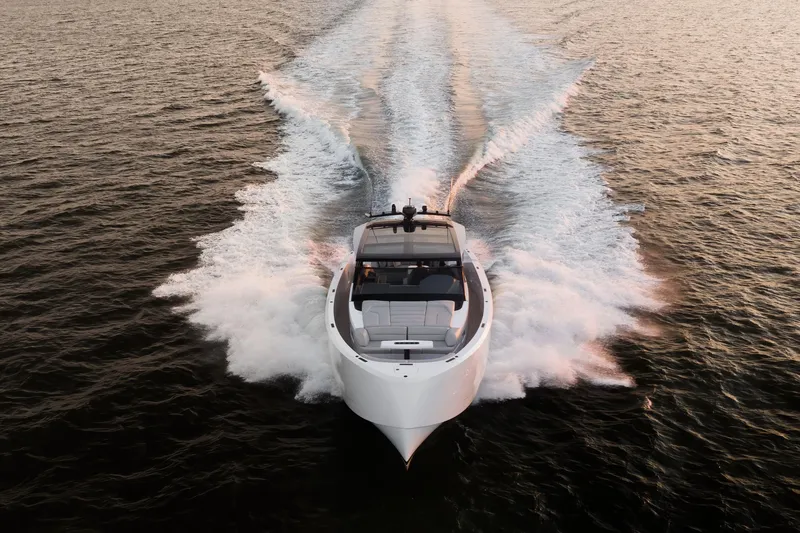 Slide: The Image of Vanquish VQ58 yacht cruising on open water at sunset, 2022 model. - 30