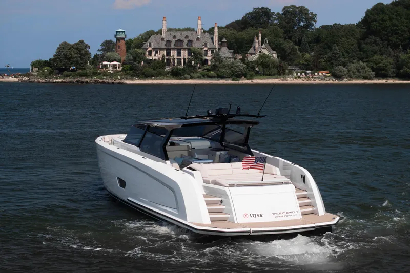Slide: The Image of Vanquish VQ58 yacht cruising near a scenic shoreline with a historic mansion, 2022 model. - 4