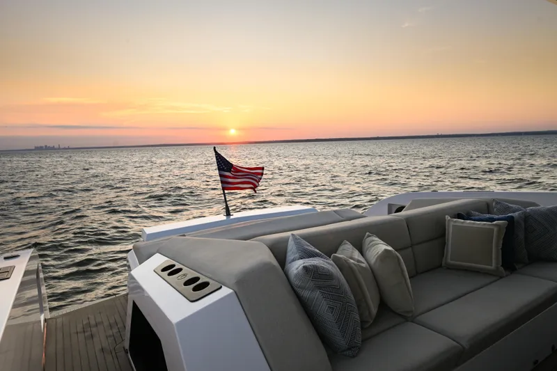 Slide: The Image of Luxury Vanquish VQ58 yacht at sunset, featuring elegant seating and an American flag. - 24