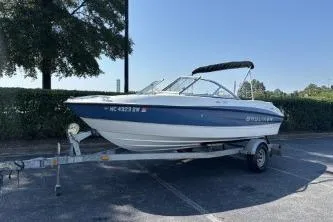 Slide: The Image of 2011 Bayliner 185 Bowrider on trailer, parked outdoors, with canopy and registration visible. - 4