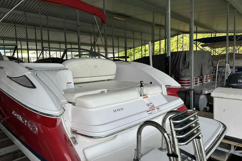 Slide: The Image of 2008 Cobalt 252 boat with red and white exterior, docked in a covered marina. - 13
