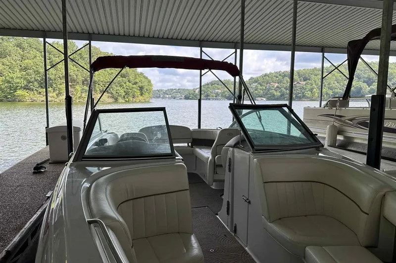 Slide: The Image of 2008 Cobalt 252 boat docked under a covered marina with scenic lake view. - 15