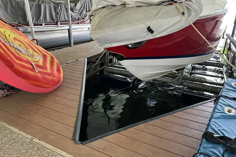 Slide: The Image of 2008 Cobalt 252 boat docked with cover, next to a colorful inflatable tube. - 17