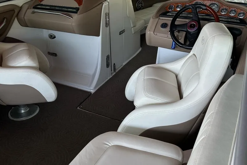 Slide: The Image of Interior of a 2008 Cobalt 252 boat with beige leather seating and dashboard. - 2