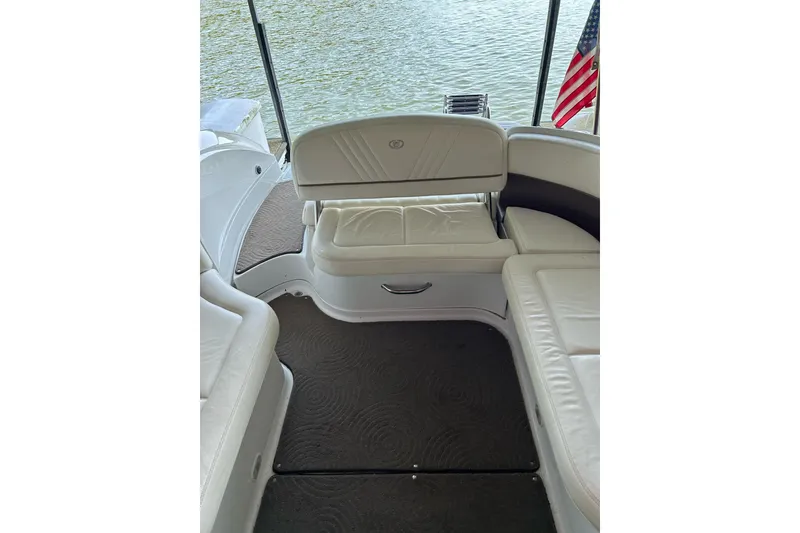 Slide: The Image of 2008 Cobalt 252 boat interior with white seating and American flag, overlooking water. - 26