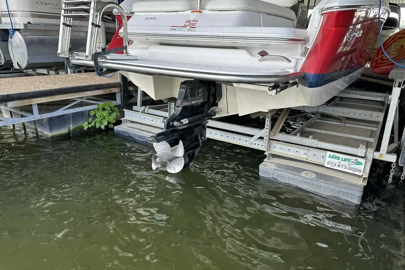 Slide: The Image of 2008 Cobalt 252 boat on lift, showing propeller and stern in marina setting. - 7