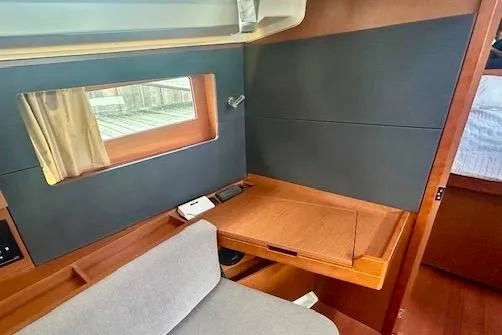 Slide: The Image of 2017 Beneteau Oceanis 41.1 interior with wooden desk and window view. - 13