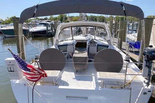 Slide: The Image of 2017 Beneteau Oceanis 41.1 sailboat docked, featuring spacious deck and American flag. - 3