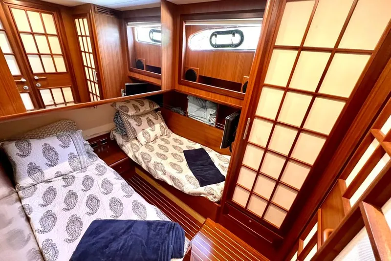 Slide: The Image of Luxurious 2006 Mochi Craft 51 Dolphin yacht cabin with elegant wood paneling and twin beds. - 11