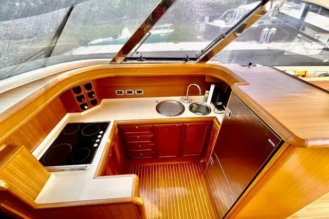 Slide: The Image of Luxurious 2006 Mochi Craft 51 Dolphin yacht kitchen with wood finish and modern appliances. - 12
