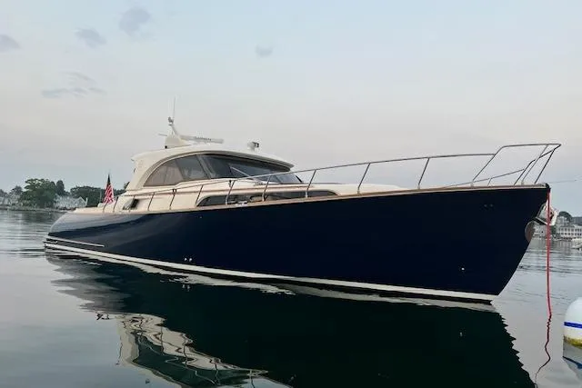 Slide: The Image of 2006 Mochi Craft 51 Dolphin yacht on calm water, showcasing sleek design and elegance. - 5