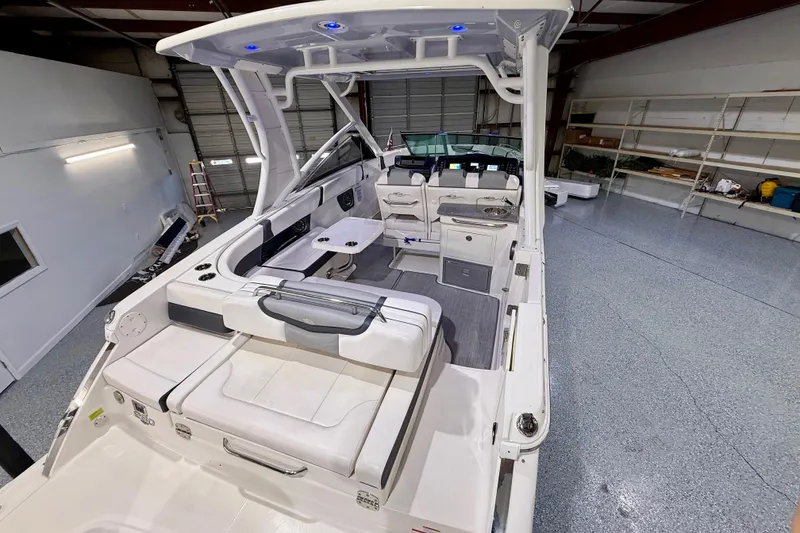 Slide: The Image of 2021 Chaparral 280 OSX boat interior with seating and control panel in a garage. - 17
