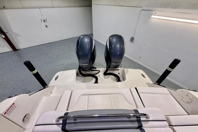 Slide: The Image of 2021 Chaparral 280 OSX boat with dual 200 horsepower engines in a garage. - 20